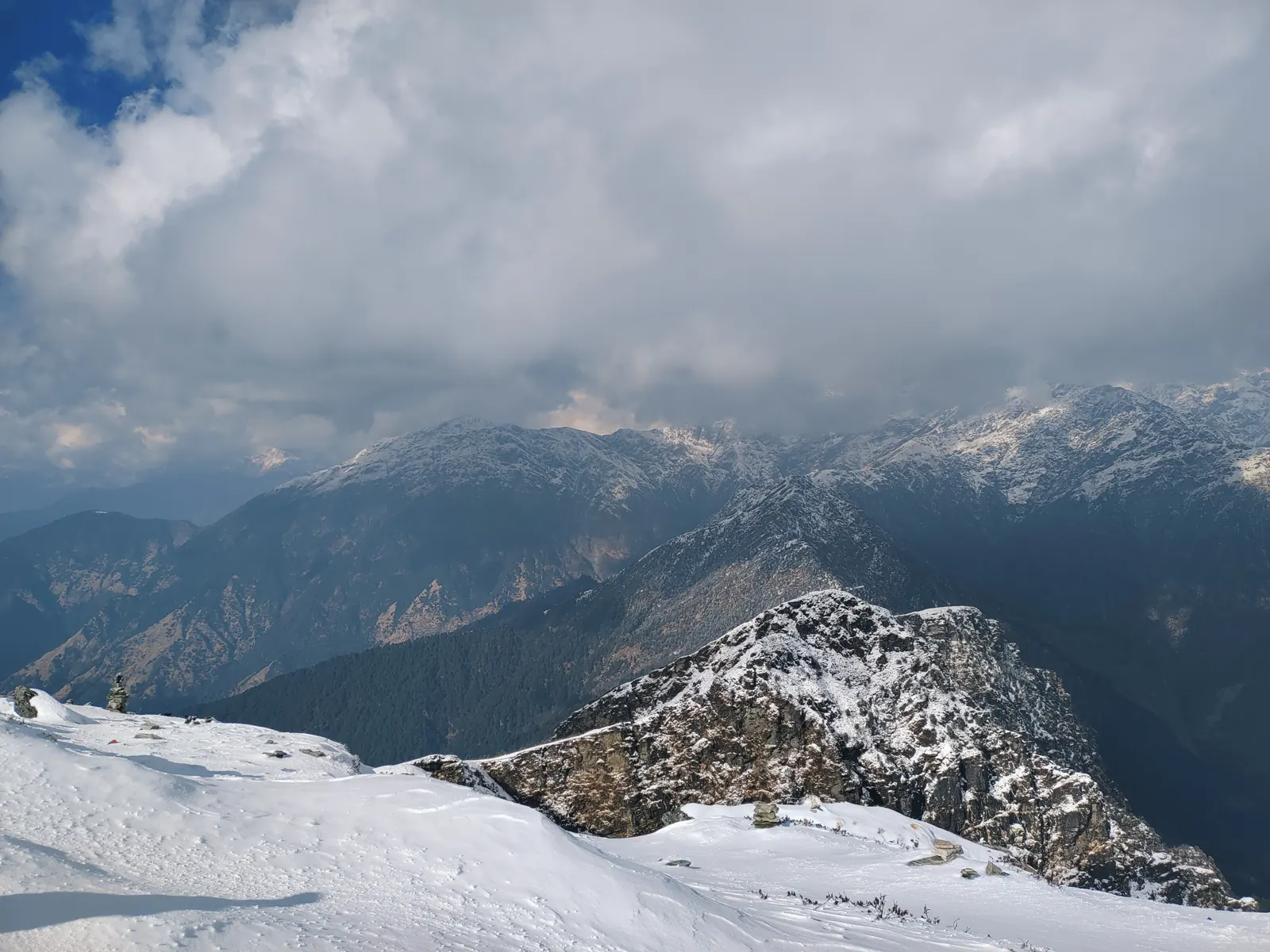 Snowy rocky ridge below cloud-covered Himalayan peaks