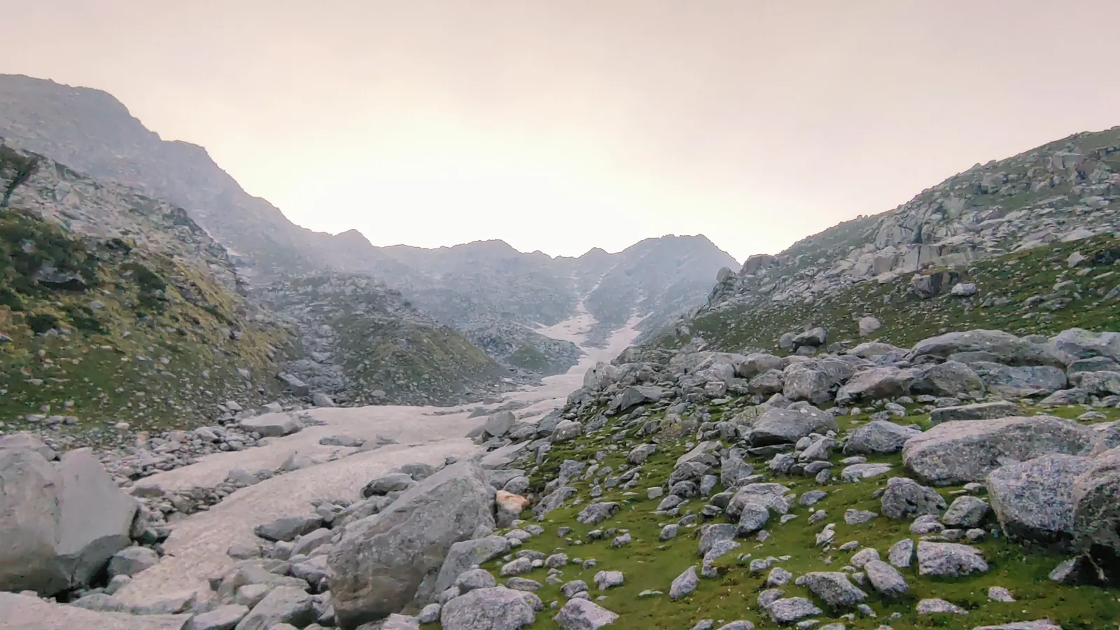 Snow and ice filling a rocky gully at the head of the valley